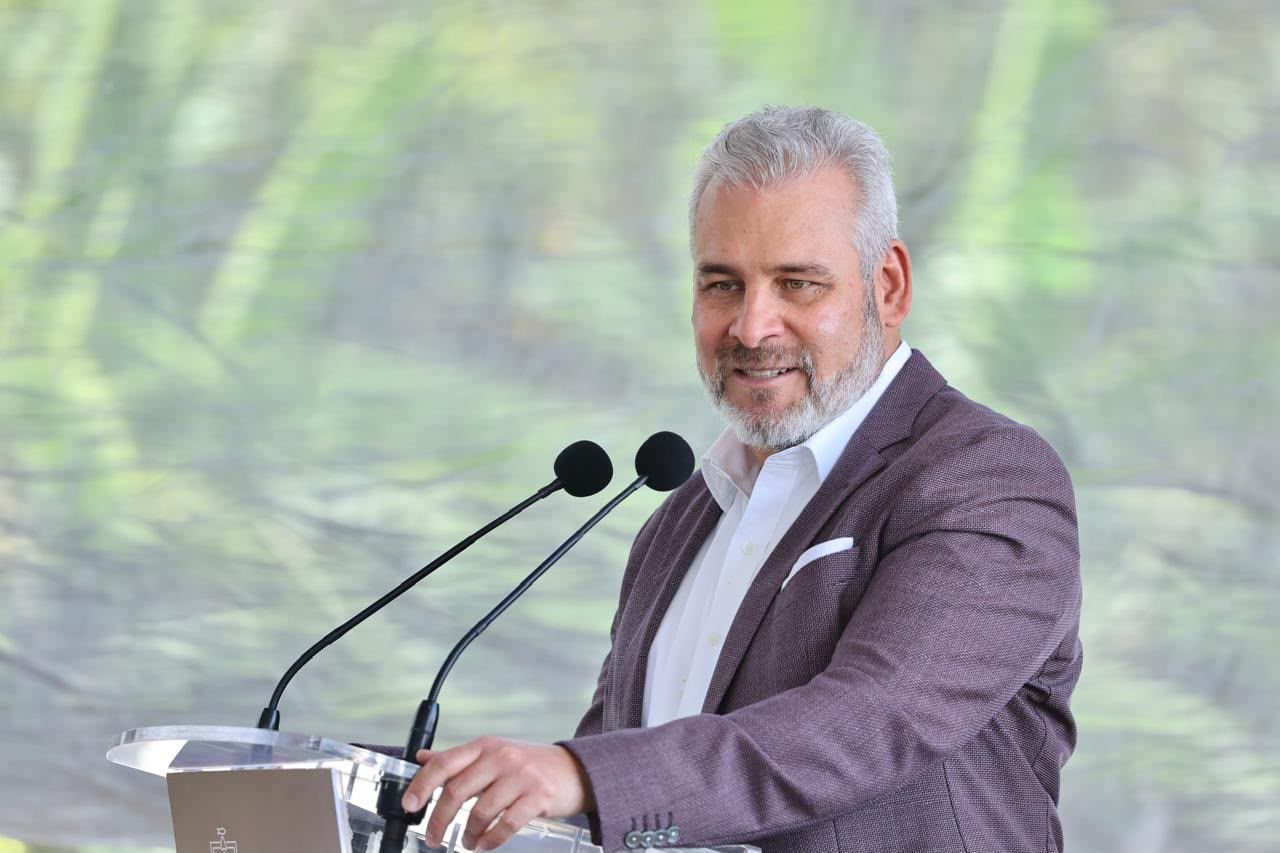 Gobernador Alfredo Ramírez Bedolla hablando ante micrófonos y bandera estatal, anunciando resultados del Plan Michoacán en Morelia.