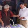 Carlos Torres Piña caminando entre personas en una comunidad rural de Michoacán, en un ambiente de cercanía y diálogo
