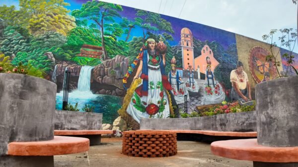 Mural monumental en la Plaza de la Ranita de Uruapan, Michoacán, mostrando escenas de la historia local, el río Cupatitzio, artesanas, cocineras tradicionales y danzas como los Negritos.