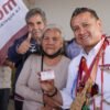 Carlos Torres Piña hablando en un evento público en Morelia, Michoacán, con fondo de bandera mexicana y letreros sobre pensiones del Bienestar