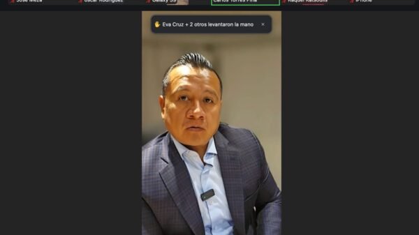 Carlos Torres Piña hablando ante micrófono en Morelia, Michoacán, durante evento sobre retorno de migrantes