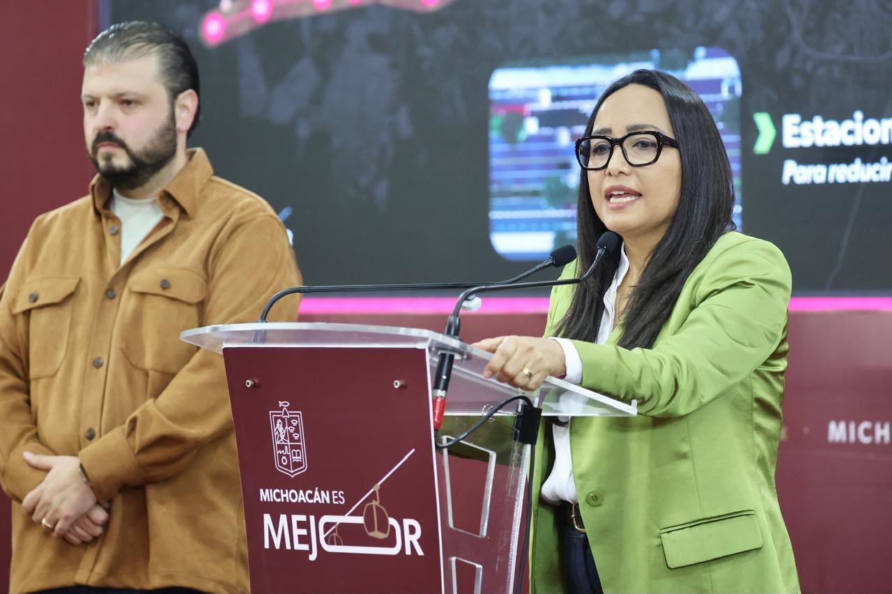 Infraestructura del sistema Morebús en construcción en Morelia, con trabajadores, árboles recién plantados y estructura de paso superior ferroviario con jardines verticales.