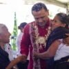 Carlos Torres Piña conversando con miembros de una comunidad originaria en un entorno rural, con expresión atenta y cercana
