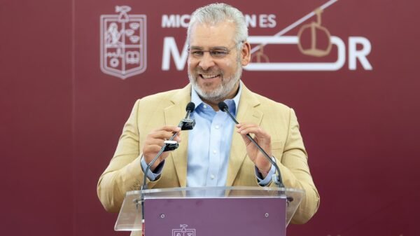 Camiones urbanos nuevos híbridos estacionados frente a edificio gubernamental en Morelia, Michoacán