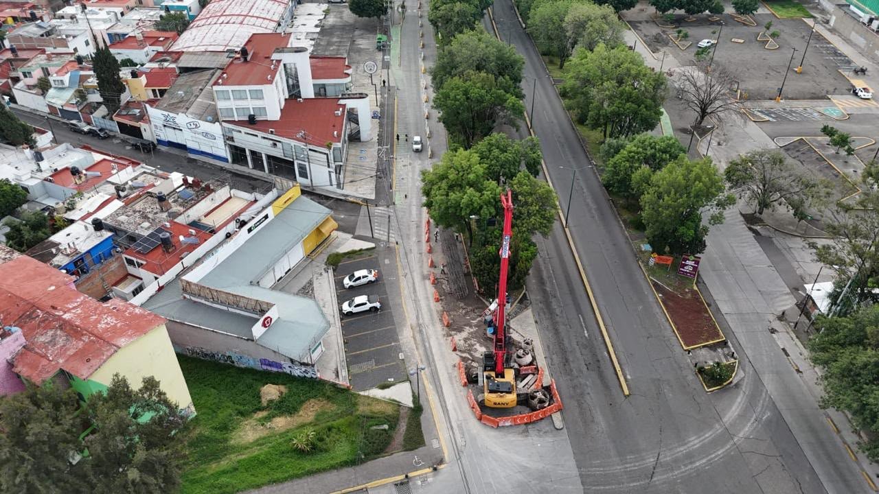 Trabajadores municipales y personal de Sedum plantando árboles jóvenes en una avenida de Morelia, con señalética del proyecto Morebús al fondo