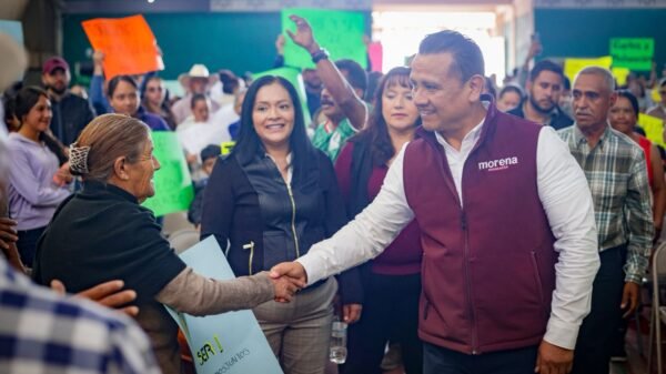 Fotografía de Carlos Torres Piña en un municipio rural de Michoacán, dialogando con habitantes locales en una plaza comunitaria