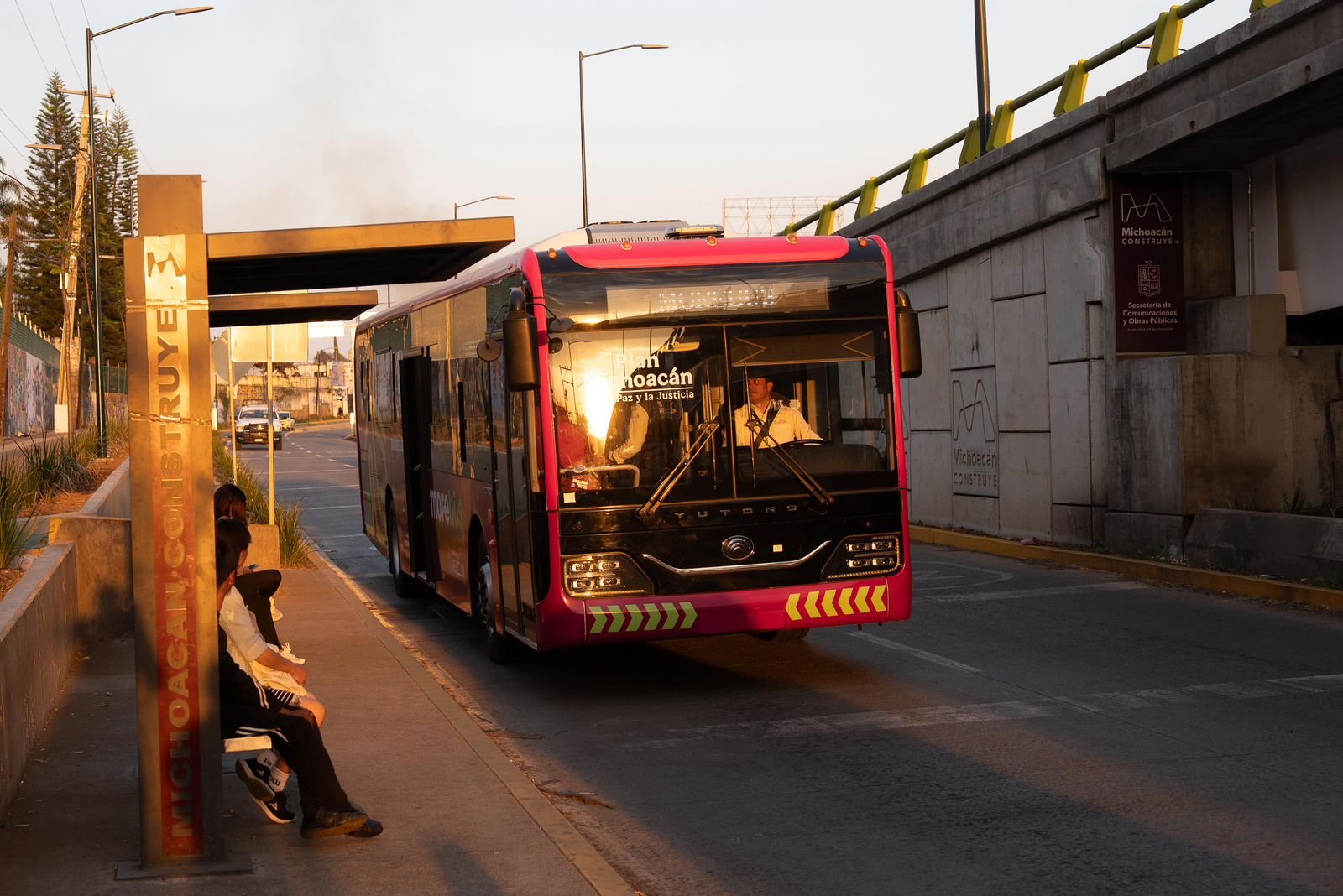 Vista aérea de una estación protegida del sistema Morebús en Morelia, con estudiantes esperando en un entorno urbano seguro y ordenado