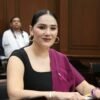 Diana Espinoza Mercado, diputada presidenta de la Comisión de Asuntos Electorales, hablando frente a una bandera de Michoacán y el logo del Congreso del Estado