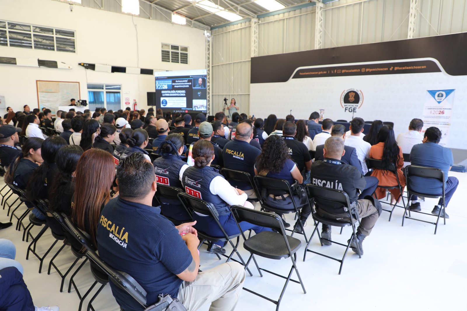 Evento presencial en la Fiscalía General del Estado de Michoacán con ponente explicando odontología forense ante personal institucional