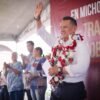 Carlos Torres Piña hablando ante una multitud en la plaza principal de Tiripetío, Michoacán, durante una asamblea informativa