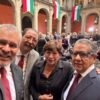 Gobernador Alfredo Ramírez Bedolla hablando en un evento oficial junto a autoridades, con bandera de Michoacán visible