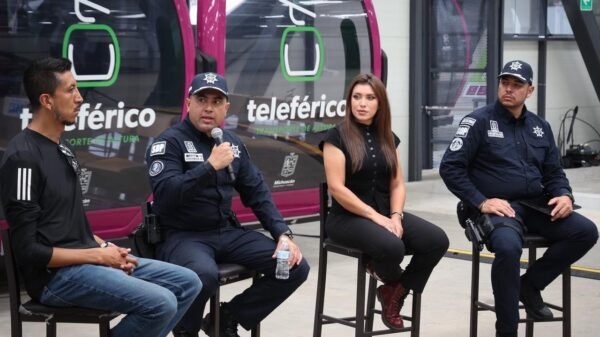 Multitud de personas corriendo en la Carrera 911 en Uruapan, con camisetas oficiales y letreros visibles sobre prevención de la extorsión