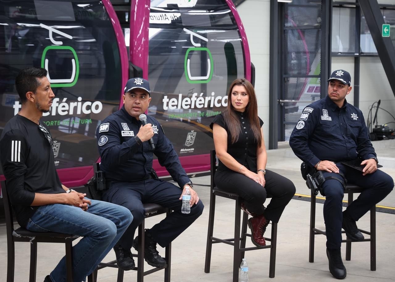 Multitud de personas corriendo en la Carrera 911 en Uruapan, con camisetas oficiales y letreros visibles sobre prevención de la extorsión