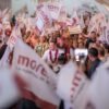 Carlos Torres Piña hablando ante una multitud en una asamblea al aire libre en Puruándiro, Michoacán, con banderas y pancartas del campo