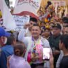 Carlos Torres Piña participando en una asamblea comunitaria al aire libre en una región rural de Michoacán, rodeado de habitantes locales