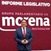Diputado Iván Arévalo Vera hablando ante micrófonos y bandera de Michoacán durante la presentación del Segundo Informe Legislativo en el Congreso del Estado
