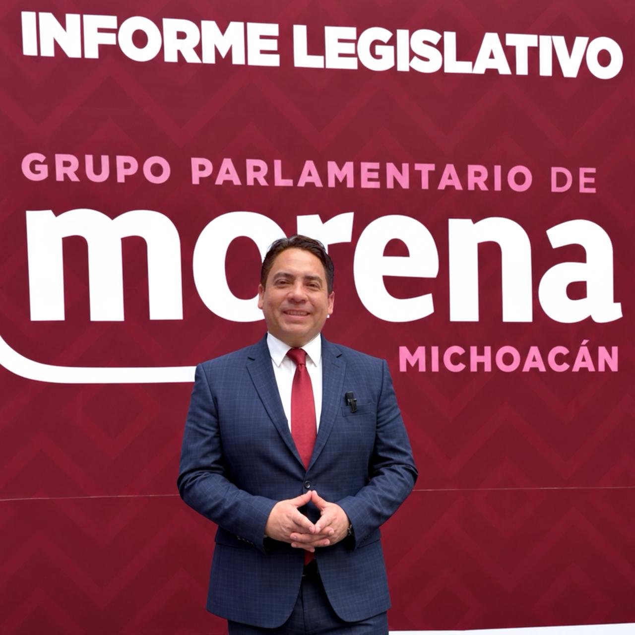 Diputado Iván Arévalo Vera hablando ante micrófonos y bandera de Michoacán durante la presentación del Segundo Informe Legislativo en el Congreso del Estado