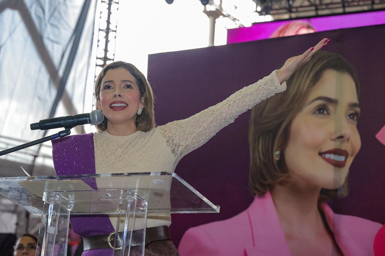 brissa arroyo segundo informe: Brissa Arroyo Martínez hablando ante micrófono en evento público en Morelia, con bandera de