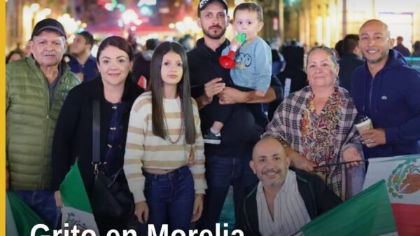 Multitud celebrando el Grito de independencia en el Centro Histórico de Morelia bajo luces festivas y banderas mexicanas