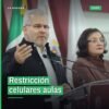 Ilustración simbólica de un celular bloqueado sobre un escritorio escolar en una aula de educación básica en Michoacán, con