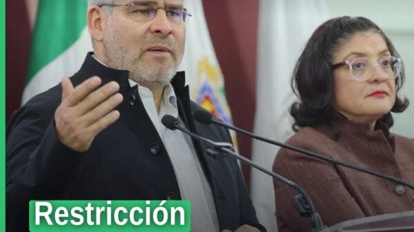 Ilustración simbólica de un celular bloqueado sobre un escritorio escolar en una aula de educación básica en Michoacán, con
