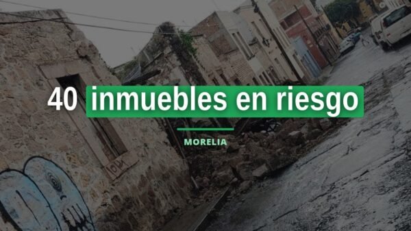 Fachada de inmueble deteriorado en el centro histórico de Morelia con lona de advertencia y estructura de apuntalamiento