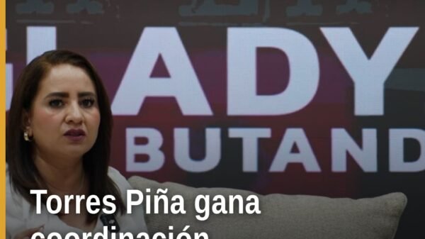 Fotografía simbólica de Carlos Torres Piña y Gladyz Butanda en evento político en Morelia, con logo de Morena Michoacán