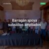 Diputado Juan Carlos Barragán hablando frente a microbuses y combis en Morelia, con letrero que menciona subsidios