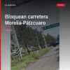 Vista lateral de varios vehículos estacionados transversalmente en la carretera Morelia-Pátzcuaro, bloqueando ambos