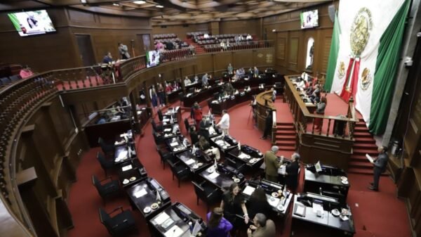 Fachada del Congreso del Estado de Michoacán en Morelia con bandera estatal y letrero simbólico que menciona el día del