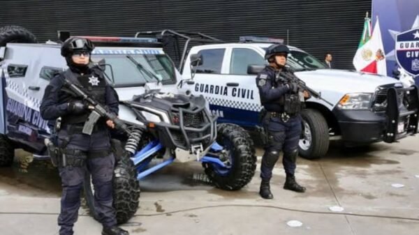 Elementos de la Guardia Civil realizando un filtro de revisión a motociclistas en una calle urbana de Uruapan, con presencia
