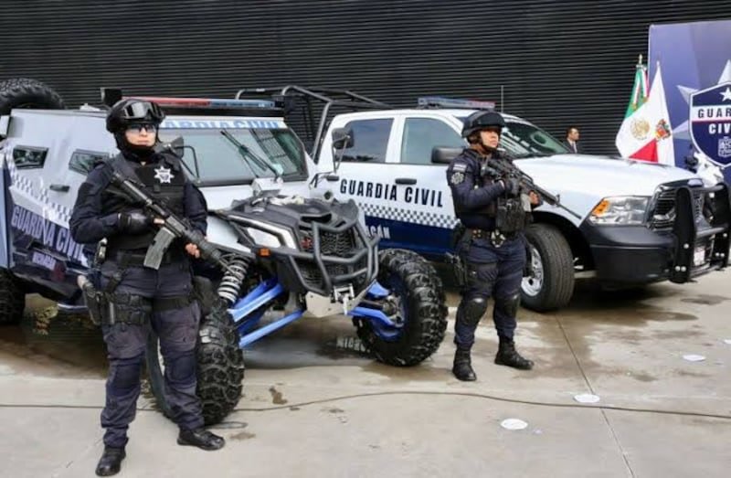 Elementos de la Guardia Civil realizando un filtro de revisión a motociclistas en una calle urbana de Uruapan, con presencia