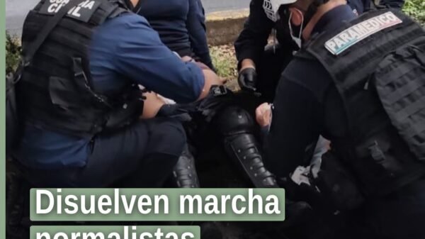 disuelven marcha normalistas: agentes de la Guardia Civil en la calle de Morelia, con manifestantes al fondo y ambiente