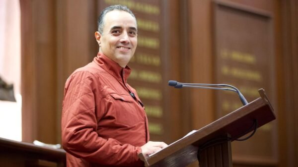 Diputado Juan Pablo Celis Silva hablando ante micrófonos en el Congreso del Estado de Michoacán, con fondo de bandera