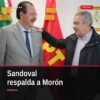 Foto de Reginaldo Sandoval Flores y Raúl Morón Orozco juntos en un acto público en Morelia, con banderas del PT y mensajes
