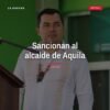 Fotografía de José María Valencia Guillén, alcalde de Aquila, frente al palacio municipal, con expresión seria, relacionada
