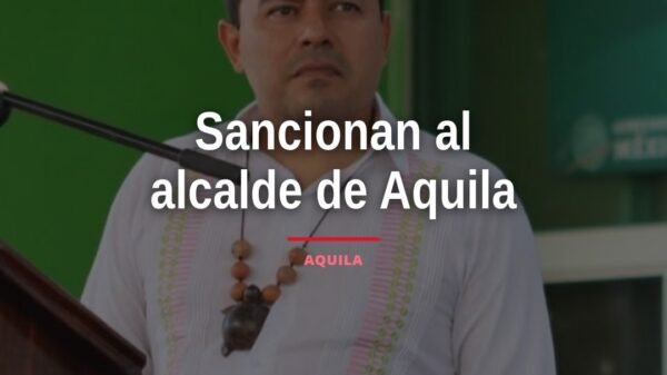 Fotografía de José María Valencia Guillén, alcalde de Aquila, frente al palacio municipal, con expresión seria, relacionada