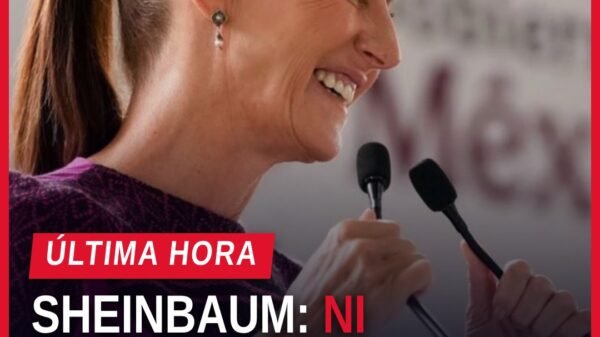 Claudia Sheinbaum hablando ante micrófono en Morelia, Michoacán, durante acto de Vivienda para el Bienestar, con bandera